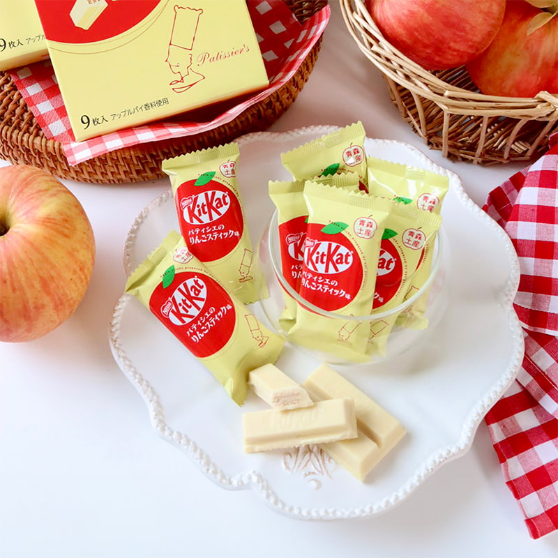 On a table, netx to some apples, a pack of KitKat "Pâtissier’s Apple Stick," in collaboration with the renowned confectionery maker Ragnoo, from Japan